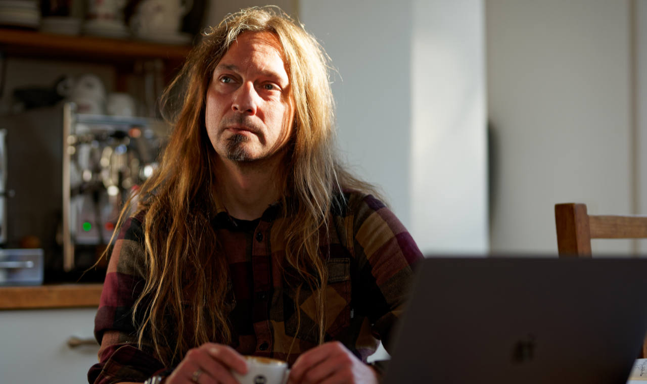 Ein Foto auf dem ich im Wal auf einer Bank sitze und auf mein Mobiltelefon schaue